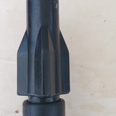 Ferramenta preta com parte superior cónica e base texturizada sobre fundo claro