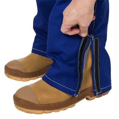 Calças de trabalho azuis com fecho de velcro e botins castanhos reforçados