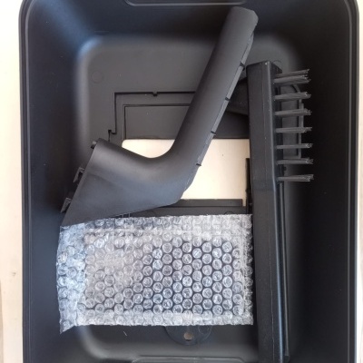 Acessórios pretos em bandeja plástica preta com fundo de madeira clara