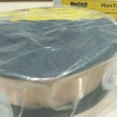 Rolo de fio ManTech M706 com embalagem plástica e caixa amarela ao fundo