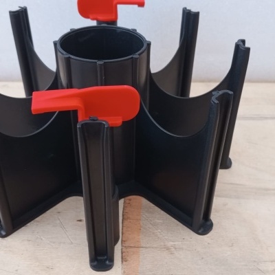 Suporte preto com divisórias e abas vermelhas sobre mesa de madeira