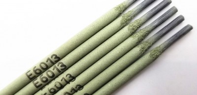 Sete varetas de eletrodos E6013 numa superfície branca