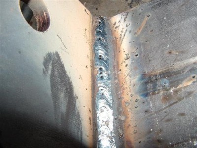 Soldadura em chapa metálica com cordão de solda e respingos