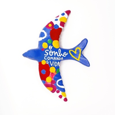 Figura decorativa em forma de pássaro colorido com texto em branco
