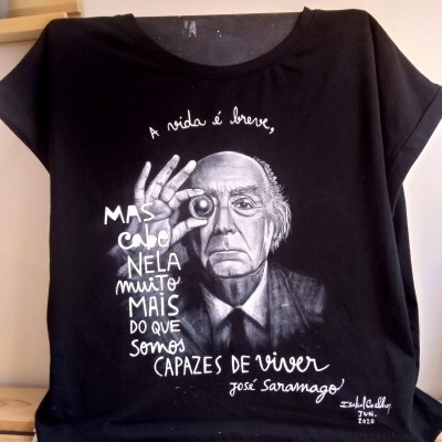 T-shirt preta com estampa artística e texto de José Saramago.