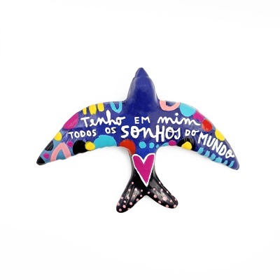 Escultura decorativa em forma de pássaro pintada com frase e padrões coloridos