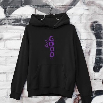 Sweatshirt preta com estampa roxa e capuz pendurada num cabide à frente de parede de tijolos