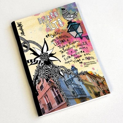 Caderno com capa ilustrada a cores com texto e desenhos de bairro, plantas e lampião
