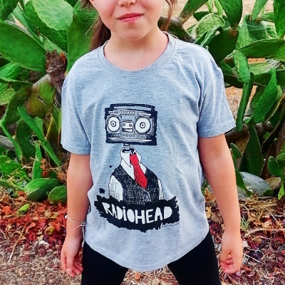 Camiseta cinzenta com estampa de figura humana e texto RADIOHEAD, usada por criança