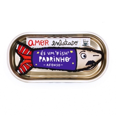 Sardinha de peluche dentro de caixa metálica com texto escrito