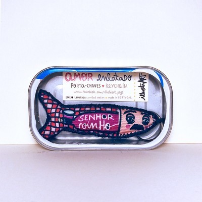 Porta-chaves em forma de peixe colorido dentro de lata metálica com etiqueta