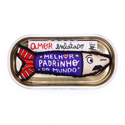 Brinquedo de pelúcia em forma de peixe dentro de lata metálica com rótulo AMOR enlatado