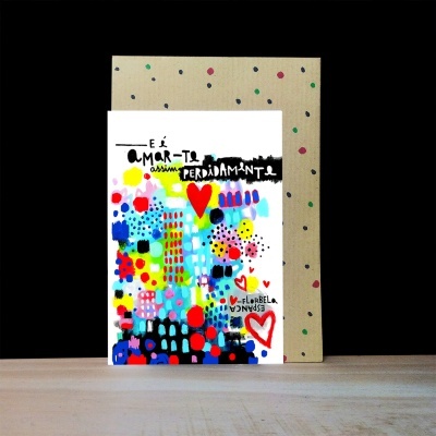 Cartão colorido com padrão abstrato e texto em português sobre uma mesa com fundo preto