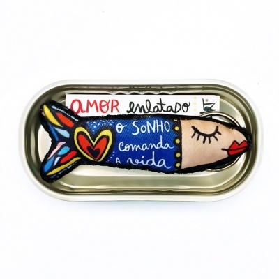 Lata metálica com peixe de tecido colorido e etiqueta com texto