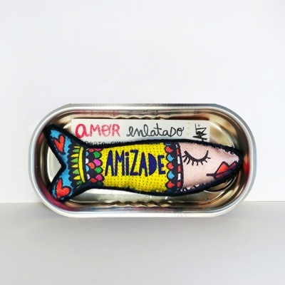 Peixe de tecido colorido dentro de lata metálica aberta com as palavras AMOR e AMIZADE