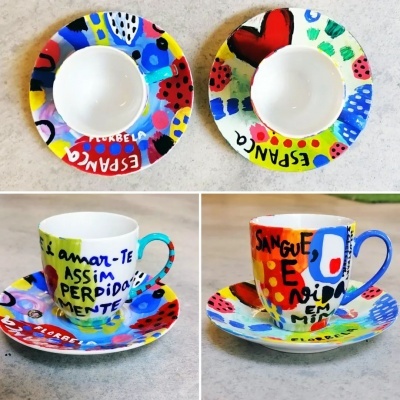 Conjunto colorido de chávenas e pires pintados à mão com texto em português e desenhos abstratos.