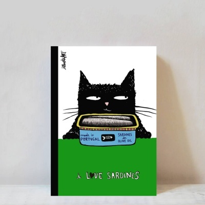 Caderno com capa ilustrada de gato e lata de sardinhas em óleo de oliva com texto relevante.