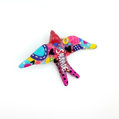 Pássaro decorativo colorido em cerâmica com a palavra 'SAUDADE'