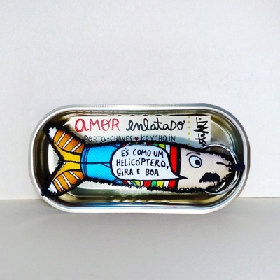 Lata metálica com figura de peixe colorido e texto em preto