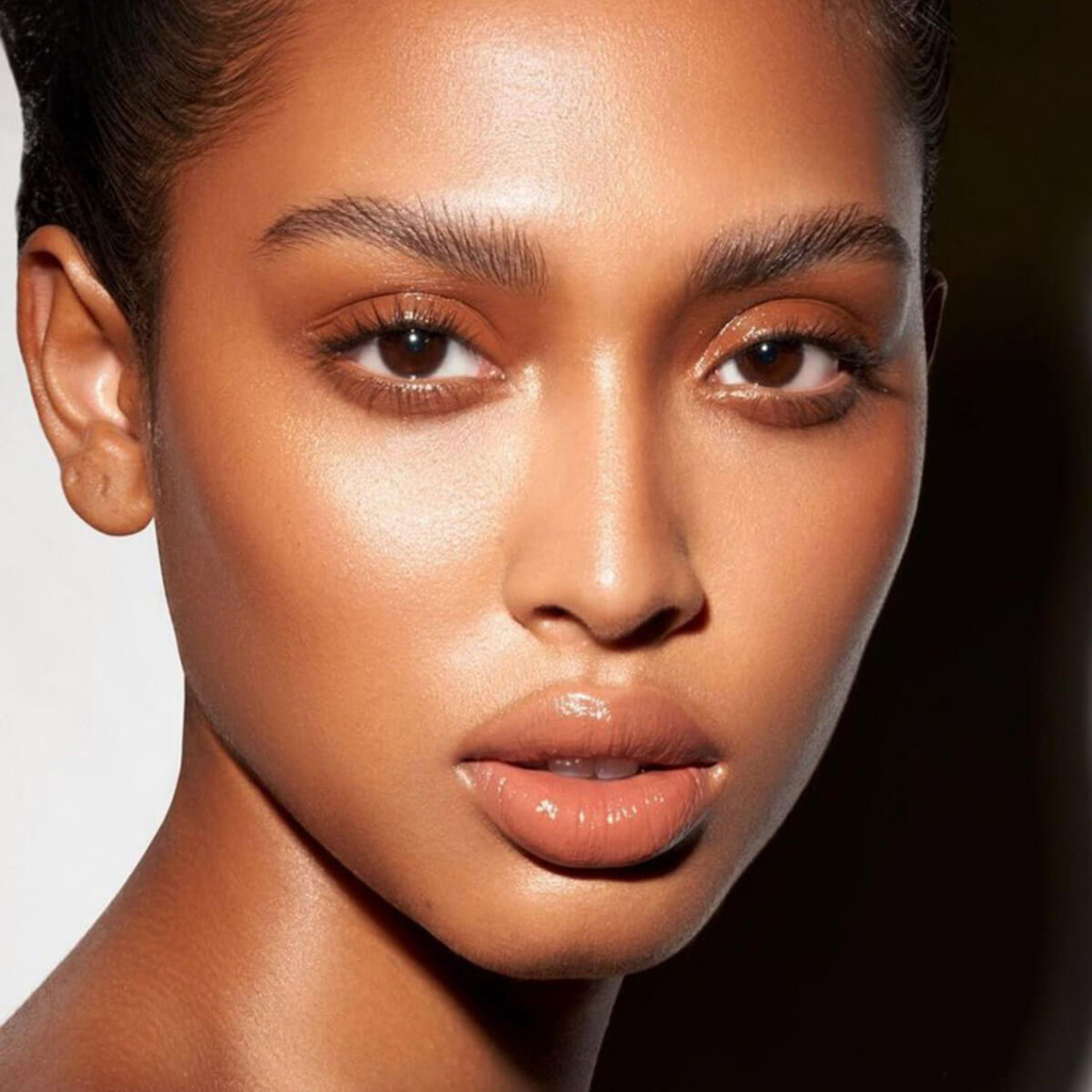 Dew Wet Balm Danessa Myricks Beauty Rosto de mulher com maquilhagem natural em tons quentes