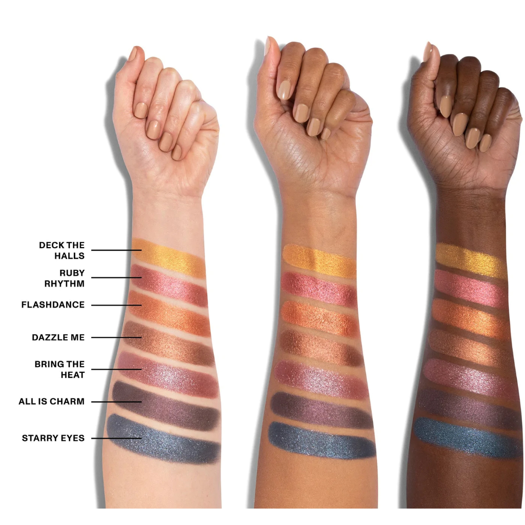 Paleta de Sombras 35XS No Silent Nights Artistry Morphe Três braços com diferentes tons de pele mostrando sombras de olhos coloridas e metálicas em amostras largas alinhadas verticalmente.