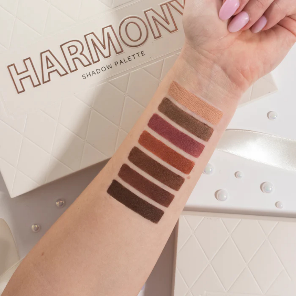 Paleta de Sombras Harmony BPerfect Paleta de sombras 'HARMONY SHADOW PALETTE' com sete tons terra aplicados no braço em cima da embalagem.