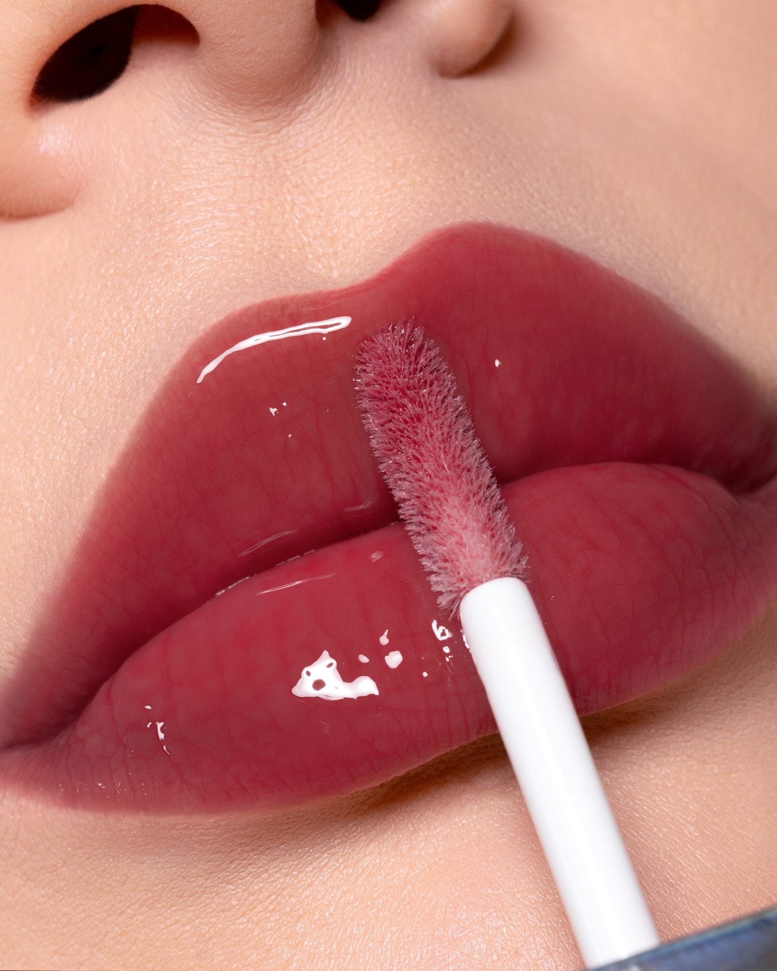 Gloss Lara Beauty Lábios com batom gloss rosa brilhante sendo aplicado