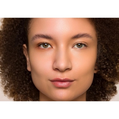 Rosto feminino com cabelo encaracolado e pele natural em close-up