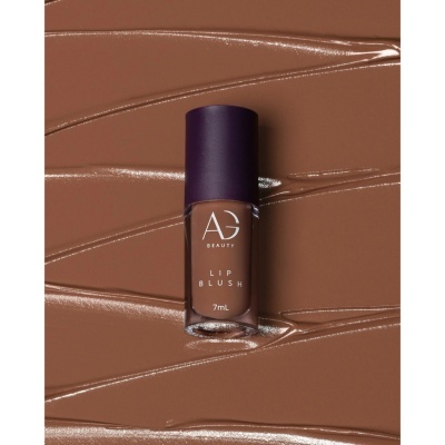 Lip blush castanho da marca AG Beauty em superfície cremosa castanha