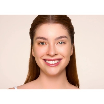 Mulher sorridente com maquilhagem natural e fundo bege