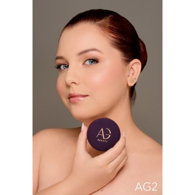 Mulher segura recipiente roxo com texto AG BEAUTY