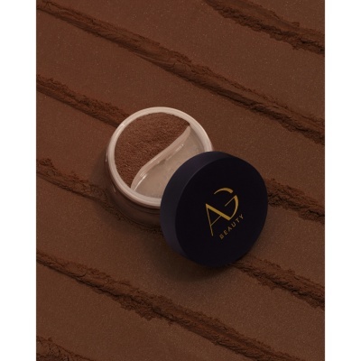 Pó solto castanho em recipiente com tampa azul escura 'AG BEAUTY'