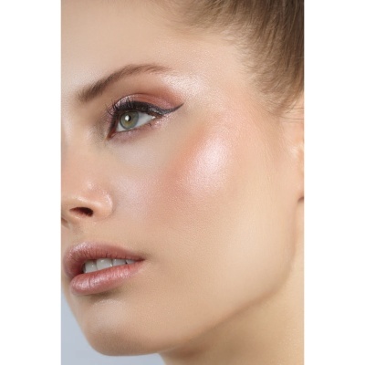 Close-up de rosto feminino maquilhado com sombra castanha e delineador preto.