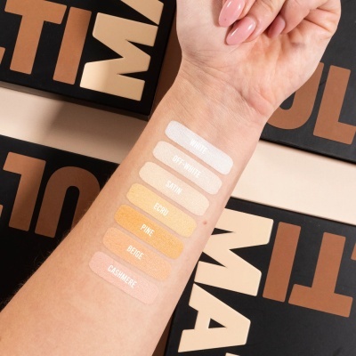 Amostras de maquilhagem em vários tons no braço com etiquetas positivas.