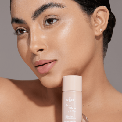 Frasco de produto cosmético bege claro com texto branco junto ao rosto de mulher