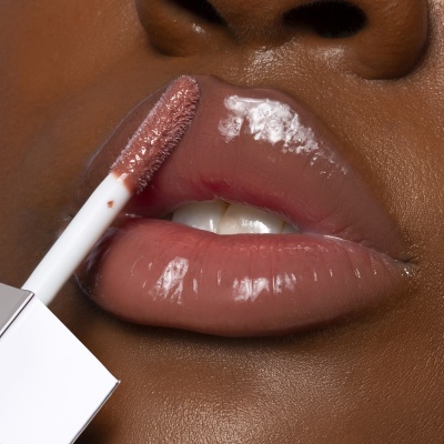 Lábios castanhos brilhantes com gloss nude e aplicador branco