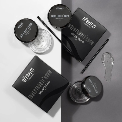 Produtos bPERFECT Indestructibrow Brow Hold em frascos e caixas pretas com texto branco e uma escova para sobrancelhas