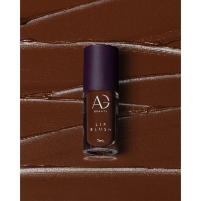 Frasco de batom líquido castanho da AG Beauty sobre textura cremosa castanha