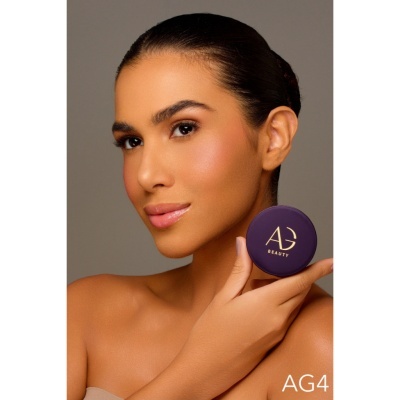 Mulher segura compacta roxa com logo AG BEAUTY dourado