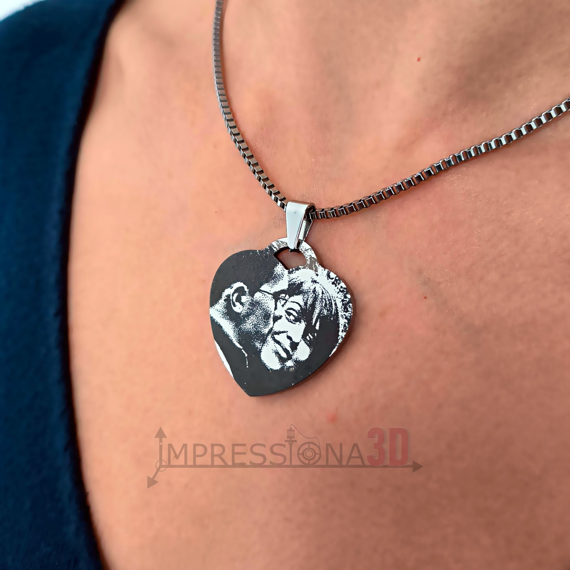 Colar de metal prateado com pendente de coração com gravura de casal