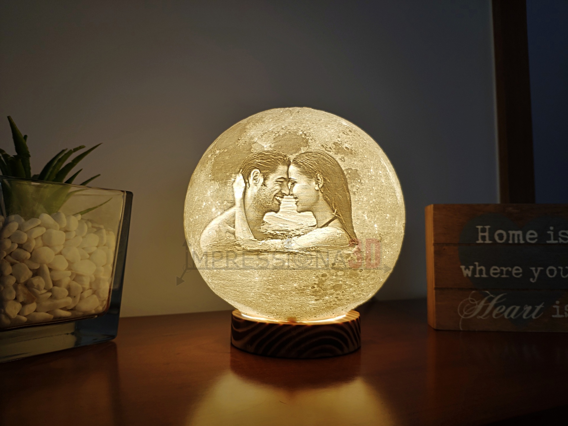 Luminária redonda iluminada com imagem de casal e decoração ao redor