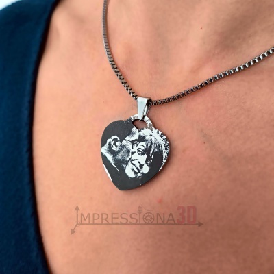 Colar de metal prateado com pendente de coração com gravura de casal