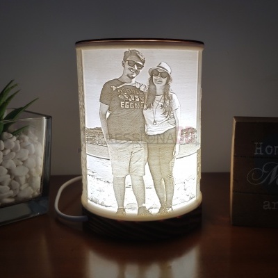 Abajur cilíndrico branco com imagem gravada de casal e base de madeira