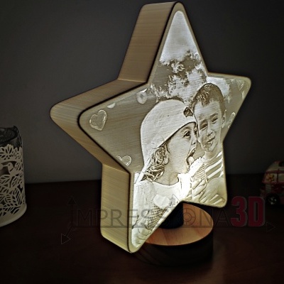 Lâmpada em forma de estrela com foto de crianças, base preta, copo decorativo e miniatura de carrinha ao fundo