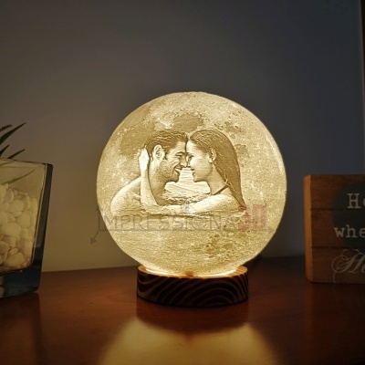 Luminária redonda iluminada com imagem de casal e decoração ao redor