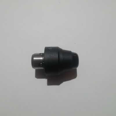 Peça metálica e plástica preta com ponta metálica prateada sobre fundo branco