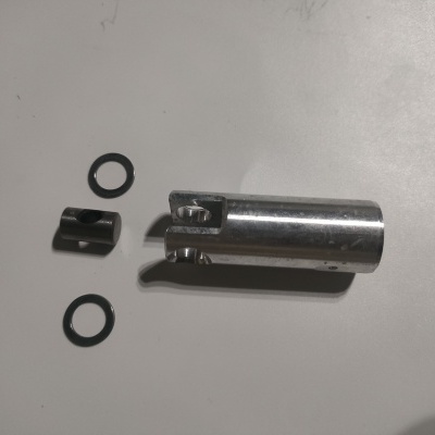 Peças metálicas e anéis de borracha sobre superfície branca