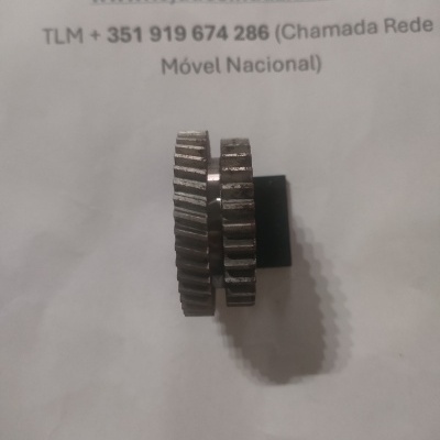 Duas engrenagens metálicas sobre papel com texto de contacto