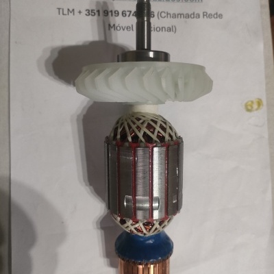 Rotor de motor elétrico com componentes metálicos e plásticos sobre papel com texto