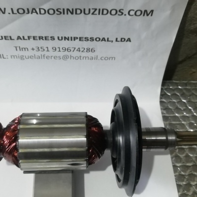 Rotor metálico com fios de cobre sobre superfície metalizada com papel informativo ao fundo